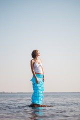 Woman enjoys on beach. Girl jumps on  waves and laughs. Model in swimsuit on  ocean vacation. Tourism and rest