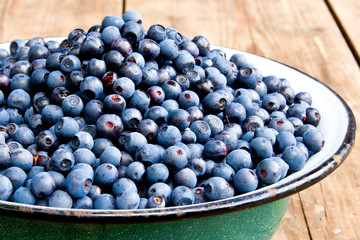 Fresh Bilberries from a bowl on old wooden table. Blueberries
