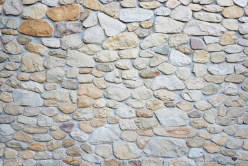Ancient medieval stone masonry. Texture of a fragment of a wall of an old structure. A background for design and creative work. Decoration and exterior decoration of the building. Construction works
