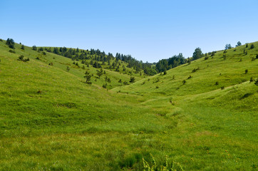 Fototapeta na wymiar Idyllic mountain landscape - with hills, pastures, fields and valleys - in spring