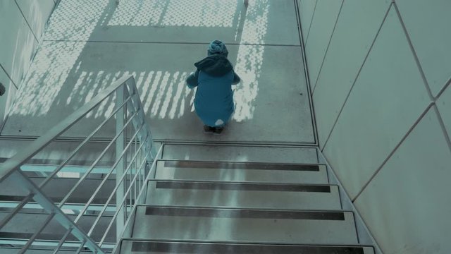 Kleiner s&uuml;sser Junge springt die Treppe hinunter