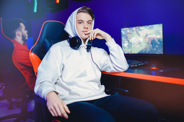 Professional gamer playing tournaments online video games computer with headphones, red and blue
