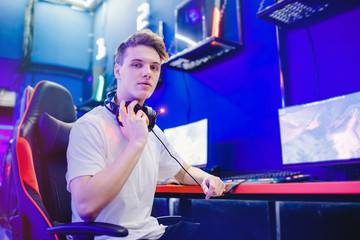 Professional gamer playing tournaments online video games computer with headphones, red and blue