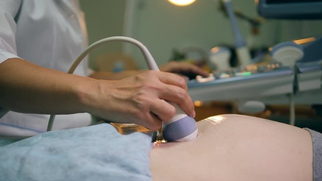 Doctor is conducting stomach ultrasound with a detector