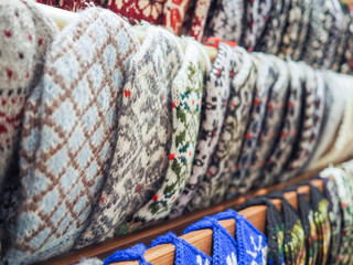 rows of multicolored knitted mittens with a pattern.  handmade, rustic style, zero waste concept