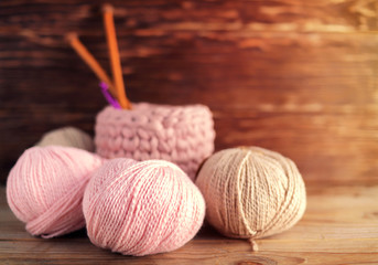 Fototapeta na wymiar Balls of pink yarn and knitting needles on a wooden background.