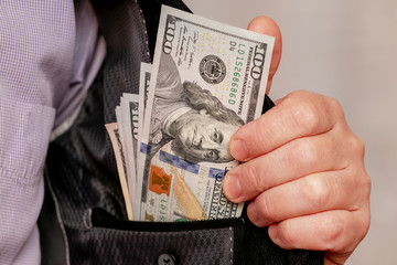 A man shows dollars hidden in his inner jacket pocket. Underground sales of dollars_
