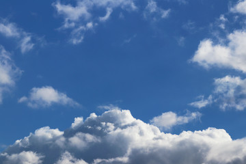 The sun shines through the cumulus clouds in the blue sky. Background and texture for artists and design. Bright light in the eyes. Water in gaseous state. The circulation of fluid in nature. Good