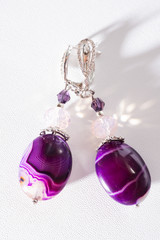 gold jewerly earrings with agat and fluorite semiprecious at white background