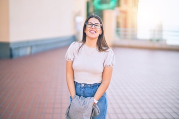 Young beautiful woman smiling happy and confident. Standing with smile on face at the town street