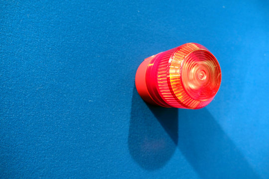Close-Up Of Red Emergency Light On Blue Wall