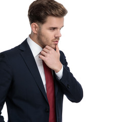 sexy young businessman looking to side and touching chin