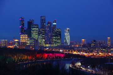 Obraz premium Russia, Moscow city Business center on Moscow river and illuminated trees background, view from Vorobyovy Gory observation deck on a winter night