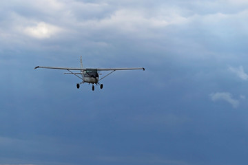 Fototapeta na wymiar Yaslo, Poland - july 1 2018: A light sport turboprop aircraft flies across the sky among the rainy clouds. Landing in difficult weather conditions. Meteorology and weather forecast for aviation