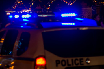 Police car with flashing lights on at night among the lights of urban illumination. Selective focus. © Виктор Кеталь