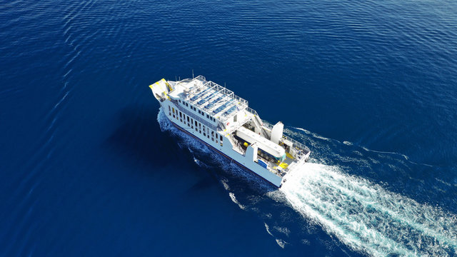 Aerial drone photo of ferry cruising from Keratisini to industrial sewage treatment plant of Psitaleia islet, Piraeus, Attica, Greece