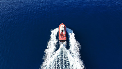 Aerial drone photo of pilot tug vessel cruising in Mediterranean container logistics port
