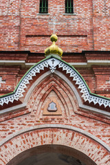 Old Orthodox church facade made of red bricks, visible Orthodox cross
