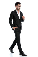 businessman walking with hand in pocket looking away pensive