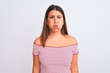 Portrait of beautiful young woman standing over isolated white background puffing cheeks with funny face. Mouth inflated with air, crazy expression.