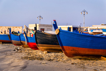 Obraz premium barche e pescherecci al porto sulla spiaggia di sabbia 