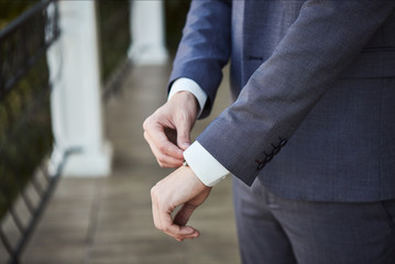 Fototapeta premium Businessman wears a jacket,male hands closeup,groom getting ready in the morning before wedding ceremony