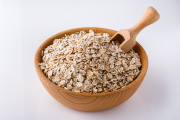 raw oat flakes on white acrylic background
