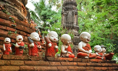 Sculpture of little monks with bowls at the buddhists temple in Ayutthaya