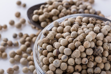white peppercorns in glass bowl with spoon