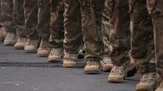 Army Soldiers parade through the streets in homecoming parade. They march in formation in camouflage. Marching.Slow Motion