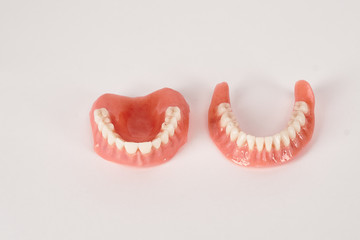 False prostheses. Dental hygienist checkup concept. Full removable plastic denture of the lower jaw.