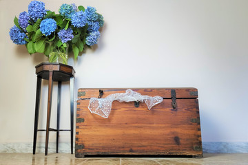 old wooden vintage chest, vase with blue  flowers