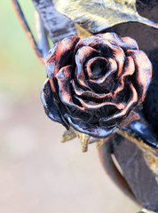 A rose flower made of wrought iron and bronze.
