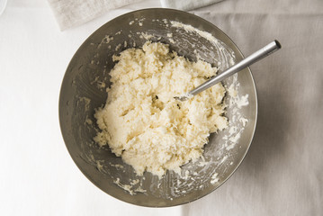 Grated white cabbage with mayonnaise in a metal bowl - a simple salad on the table. Top view