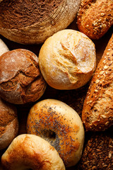 Different types of bread, bread and rolls on a wooden background, close up