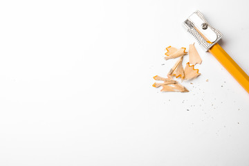 Graphite pencil, shavings and sharpener on white background, top view. Space for text