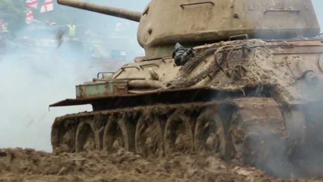 Armoured military Tanks driving through the mud. The Army vehicles are splashing. War / Battle scene