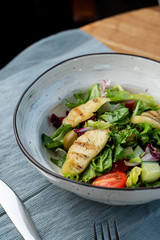 Halloumi cheese salad with mixed greens and tomatoes top view