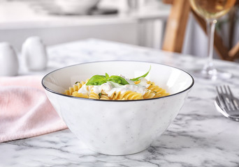 Delicious pasta with sauce served on white marble table