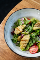 Halloumi cheese salad with mixed greens and tomatoes top view