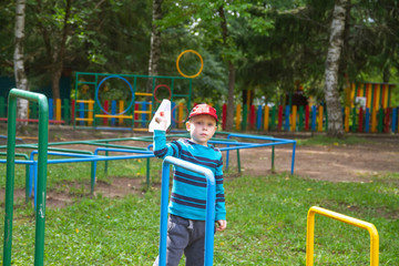 Boy on the Playground runs a paper airplane