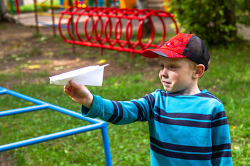 Boy on the Playground runs a paper airplane