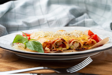Cannelloni stuffed with turkey and vegetables, with melted cheddar and mozzarella cheese close up