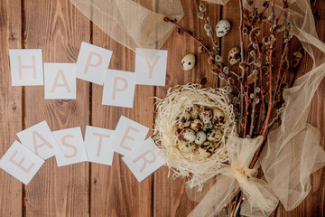 Flat lay composition of quail eggs and card with text Happy Easter on wooden table. Top view.