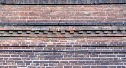 Old red brick facade of building - details of brick walls, cornice,  arches