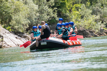 Rafting team goes down the river on the beautiful sunny day.