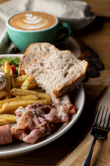 Close up of continental breakfast with bacon, roasted sausage poached egg and salad