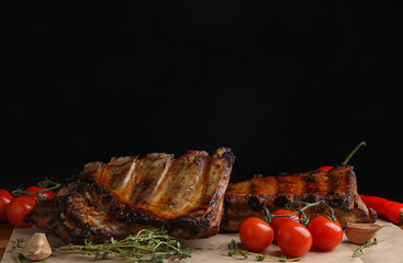 Tasty grilled ribs with tomatoes on table