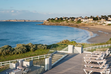 Sunbeds and sandy beach in Dinard, famous holiday destination on Breton coastline, with Saint-Malo...