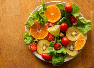 Vegetable Salad with tomato, orange, olive, spinach, lemon, kiwi, 